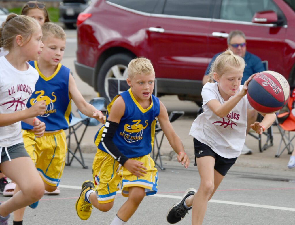 Children race outdoors in colorful sportswear during a playful competition.