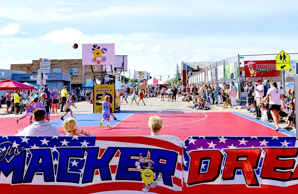 Outdoor basketball game with kids playing on a colorful court.