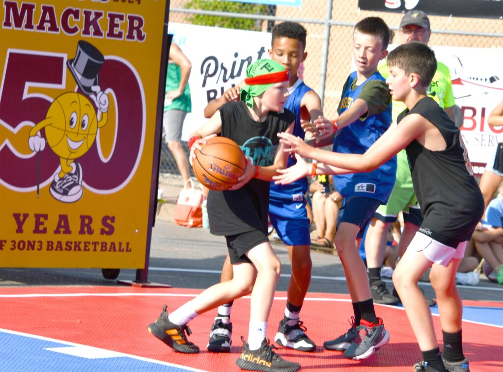Youth basketball players contesting ball on court