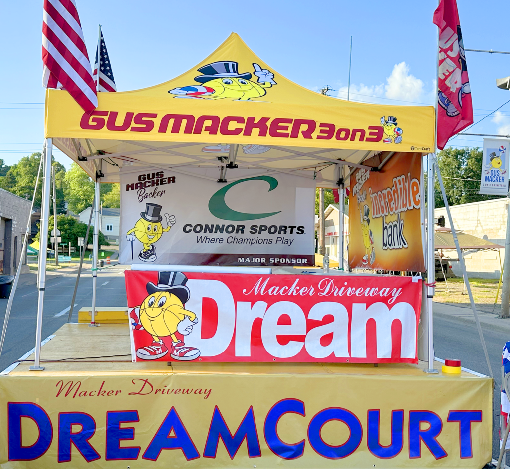 Colorful sports booth with banners and flags at an outdoor event.